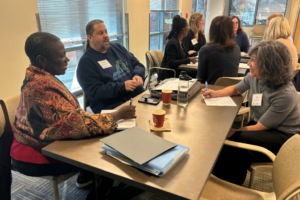 Participants at Leadership Center of Arlington's On Board program sitting around a table having a discussion